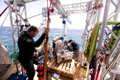 Aluminum truss rigging on a boat while a crew works over water