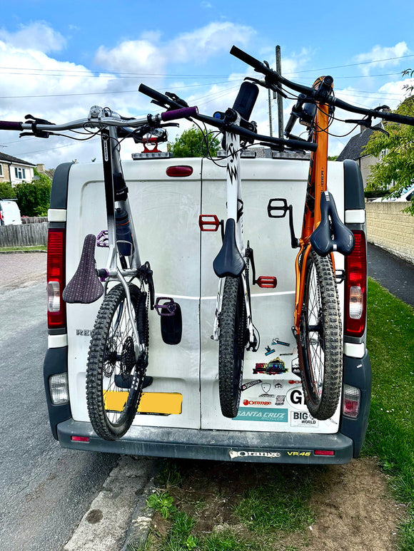 Renault Trafic with a vertical bike rack carrying three bicycles on the rear doors