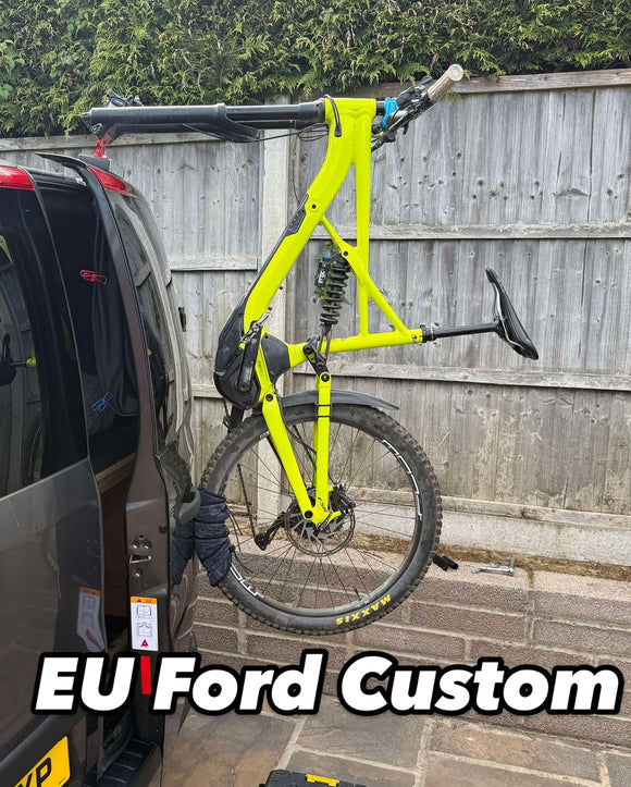 Fork mount bike rack installed on a Ford Transit Custom rear door using the Bike-Hook system. Holds bikes vertically without drilling or a hitch, perfect for campervan travel.

