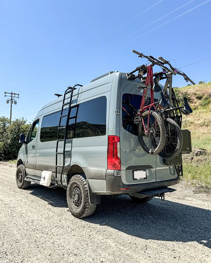 Bike-Hook system mounted to the rear doors of a Mercedes Sprinter van, showing space-saving vertical bike storage for road, mountain, or e-bikes.


